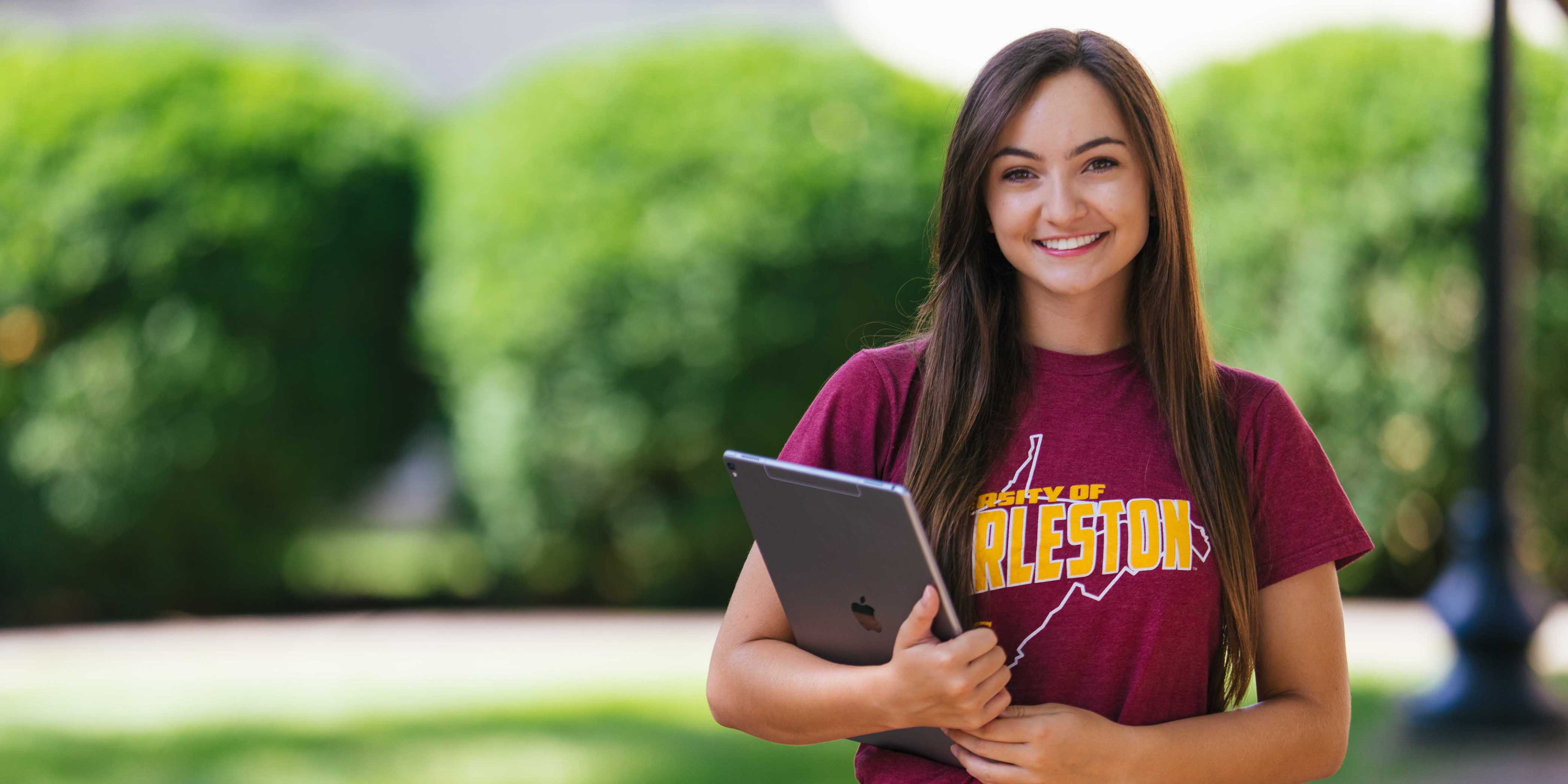 smiling female student posing with tablet