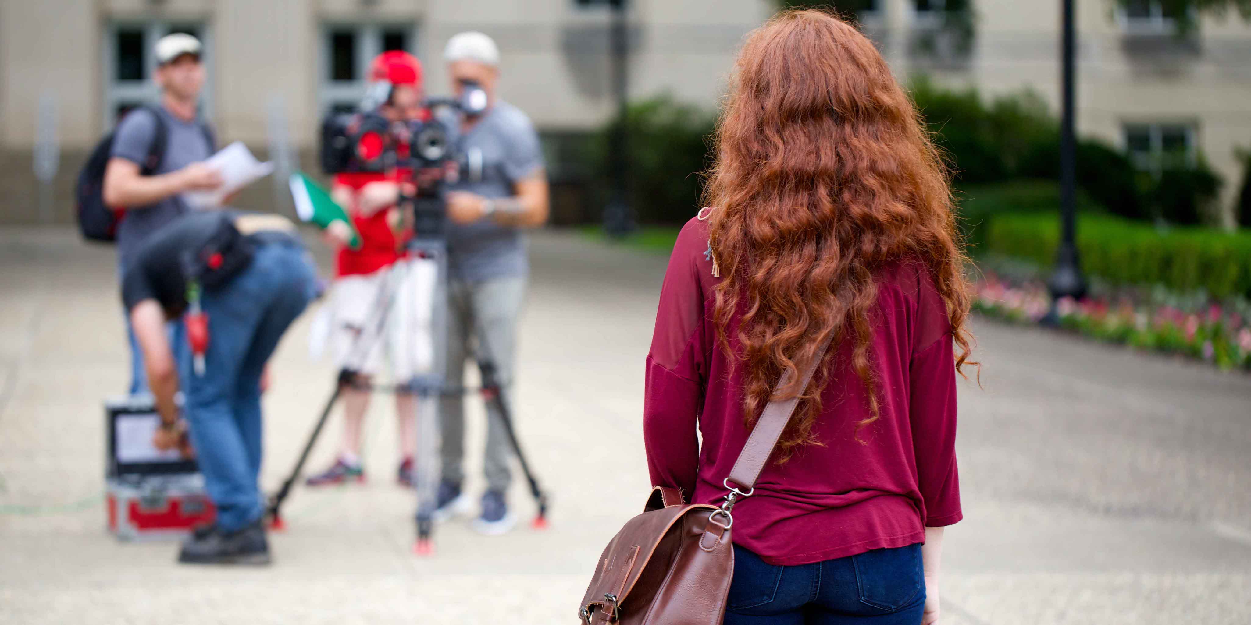 female student with messenger bag facing away from camera