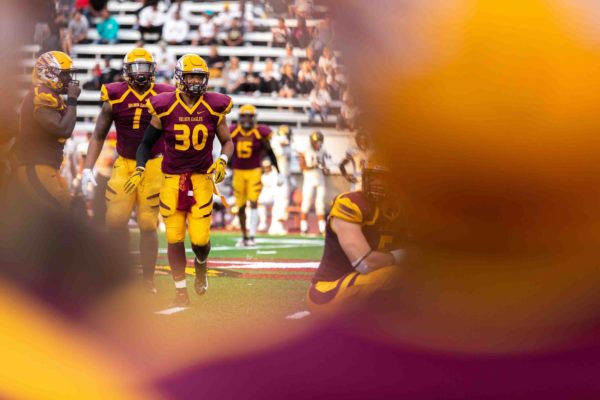 UC football players on the football field during a game