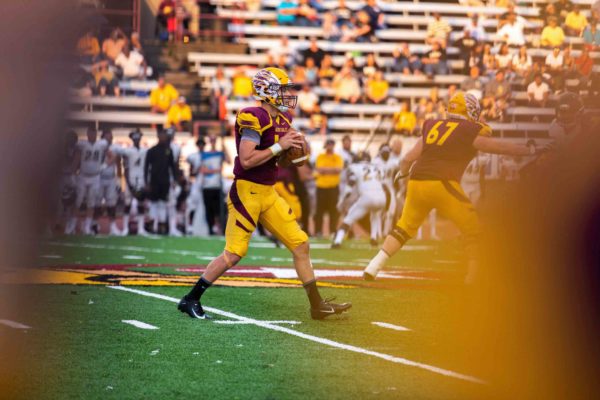 UC football player getting ready to throw football during a game