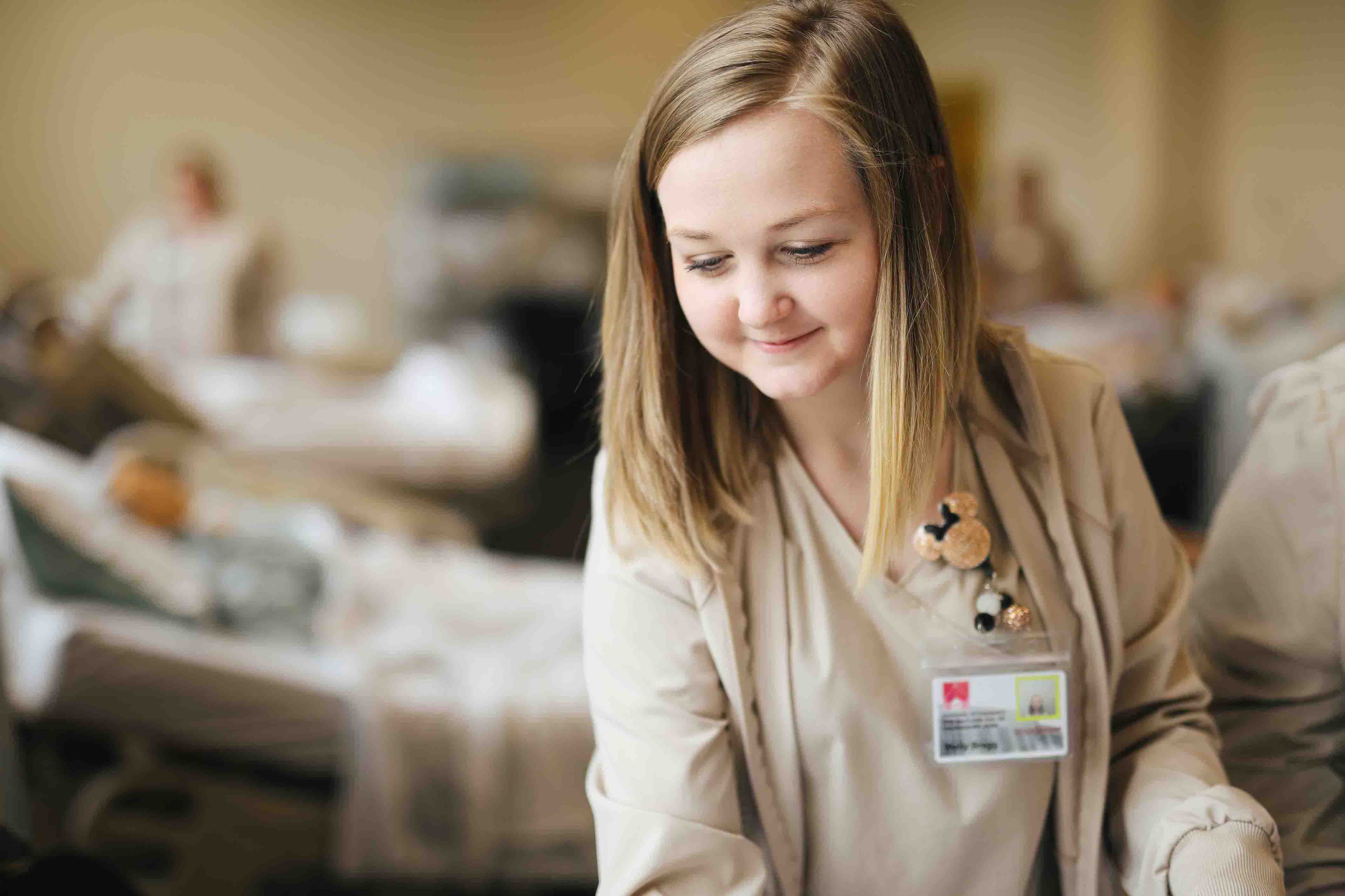 nursing student in scrubs looking down