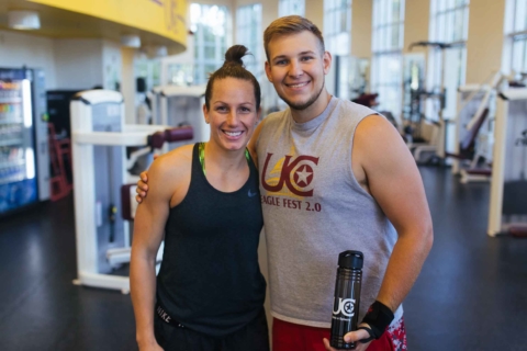 male and female in workout apparel posing in fitness center