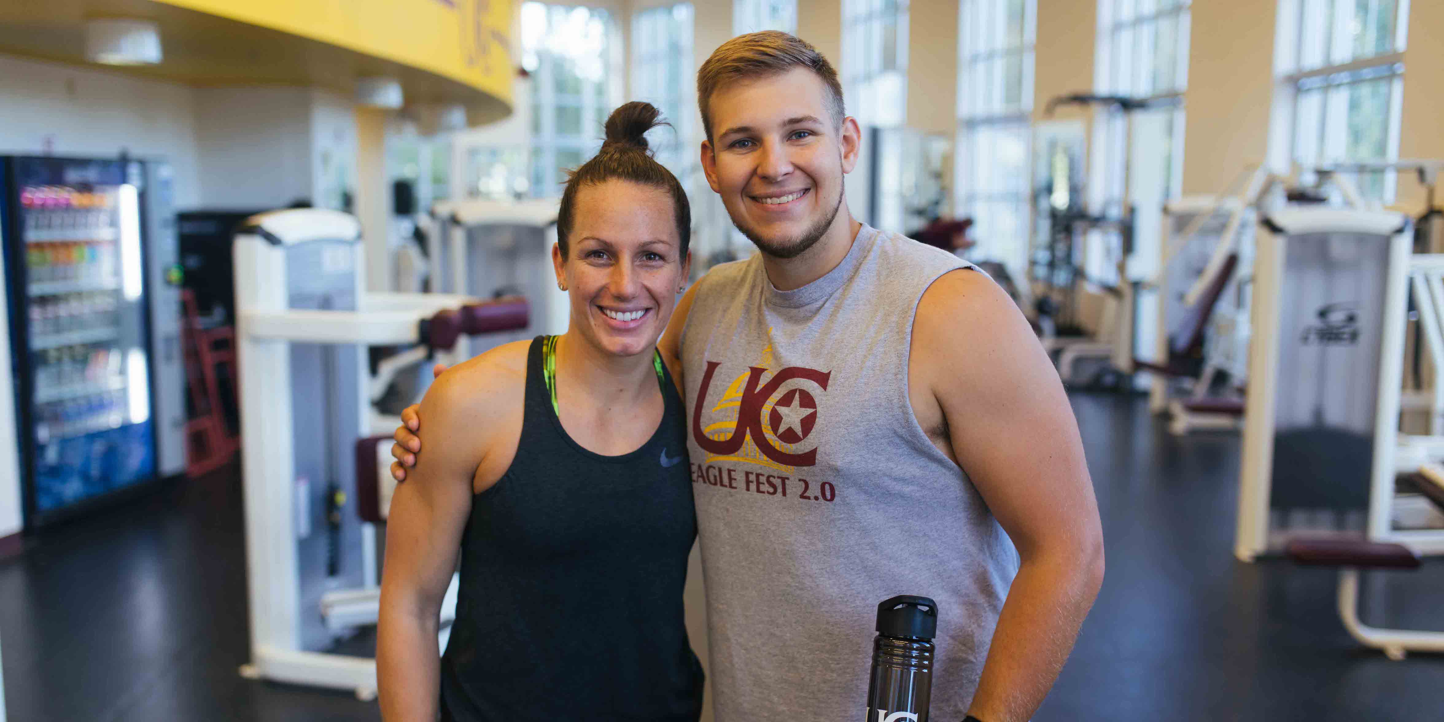 male and female in workout apparel posing in fitness center