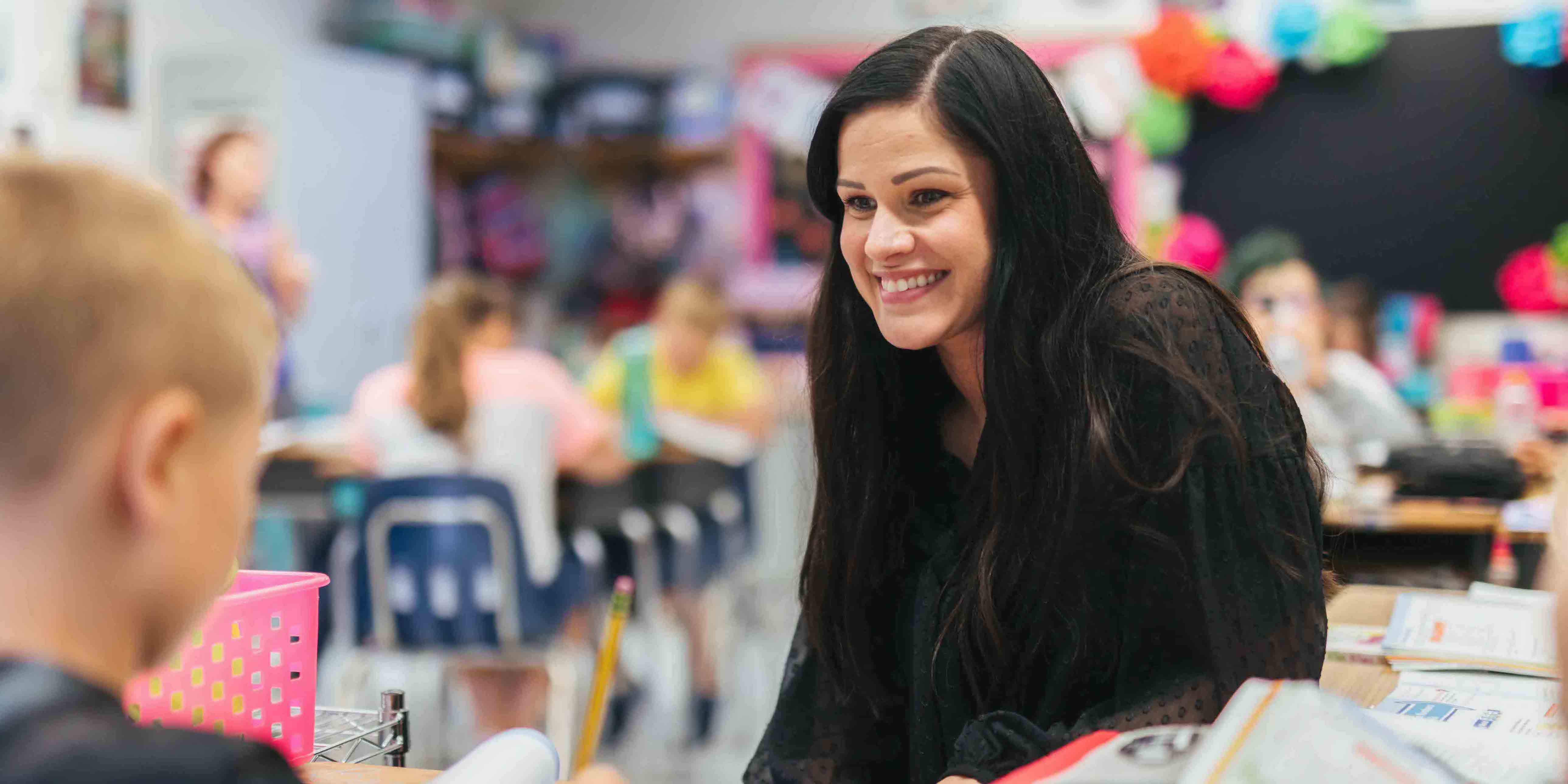 female student smiling at male elementary student