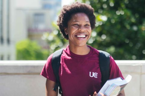 smiling female with backpack and books