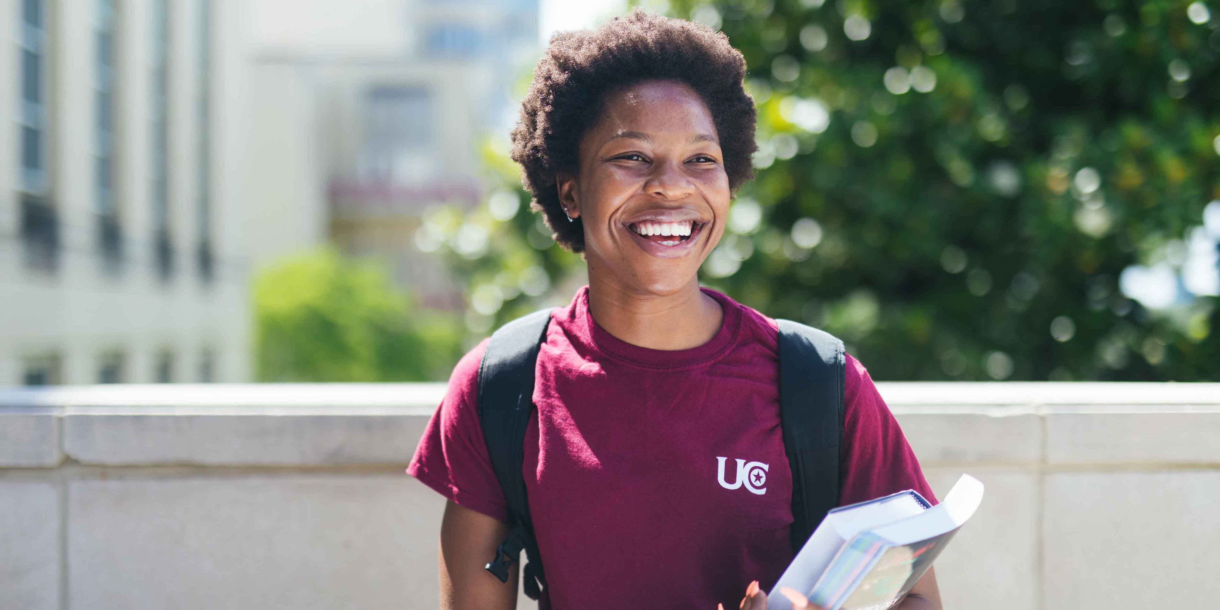 smiling female with backpack and books