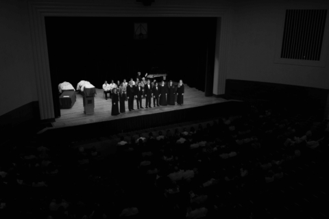 balcony view of UC choral group performing on stage at pharmacy event