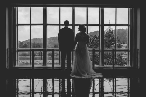 back view of bride and groom standing in front of window overlooking capitol dome