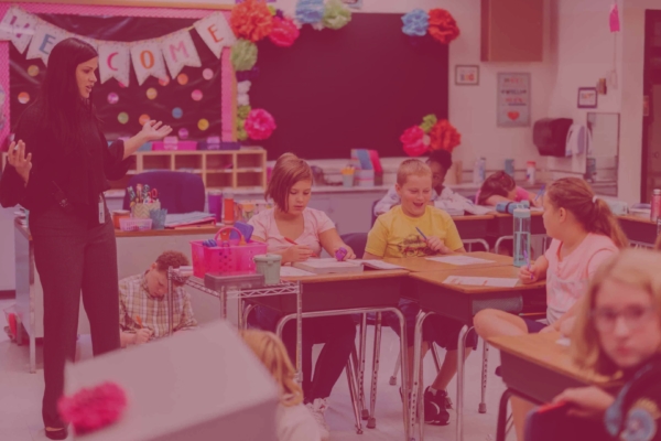 student teacher instructing elementary students in classroom