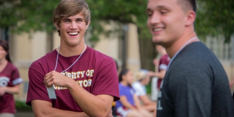 Two male students smiling outside