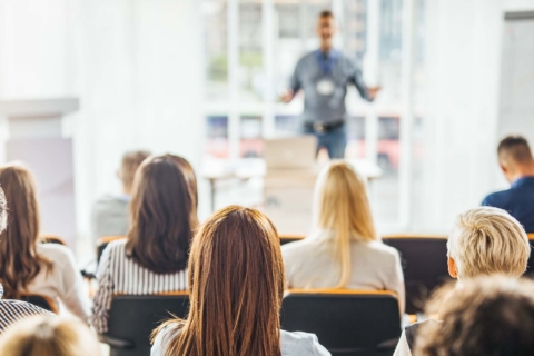 Back view of large group of business people having a training class in a board room.