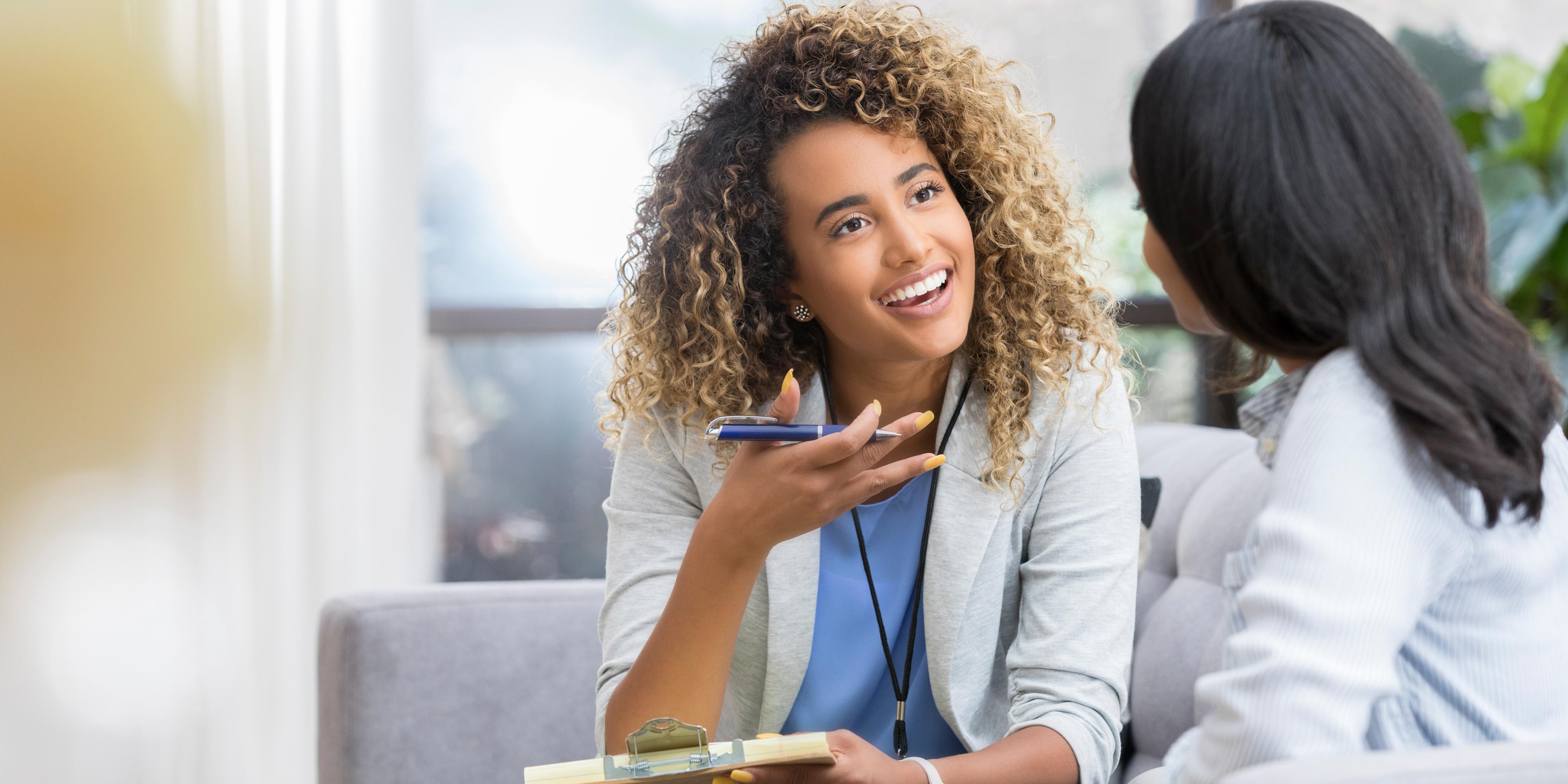 Positive young female gestures as she talks with another female.