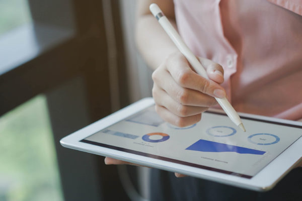 close up on businesswoman hand using stylus pen for writing on screen dashboard tablet