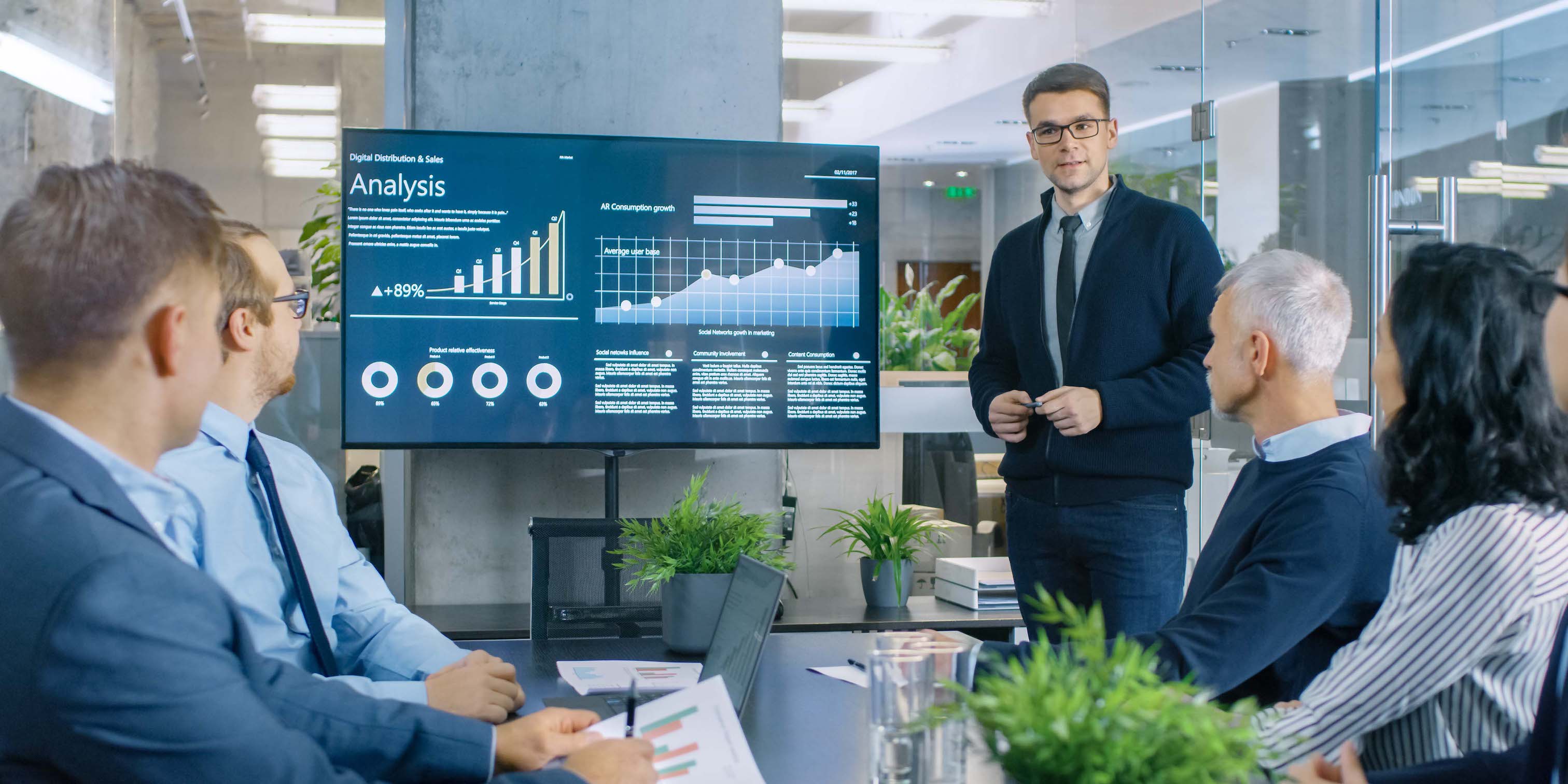 team of professionals having a meeting in conference room looking at digital data on screen