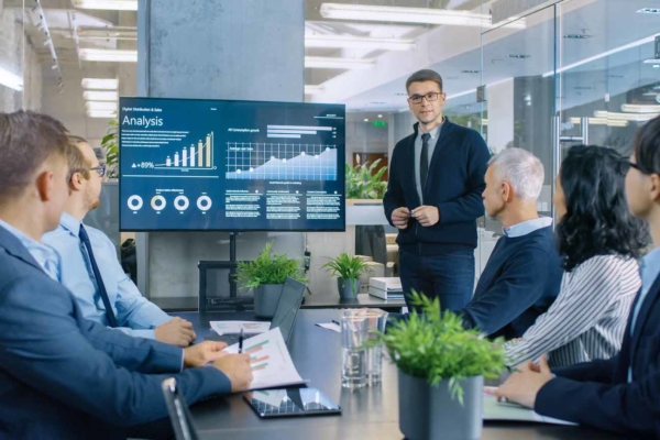 team of professionals having a meeting in conference room looking at digital data on screen