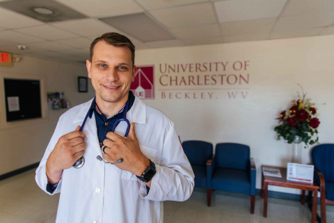 man student standing in white lab coat