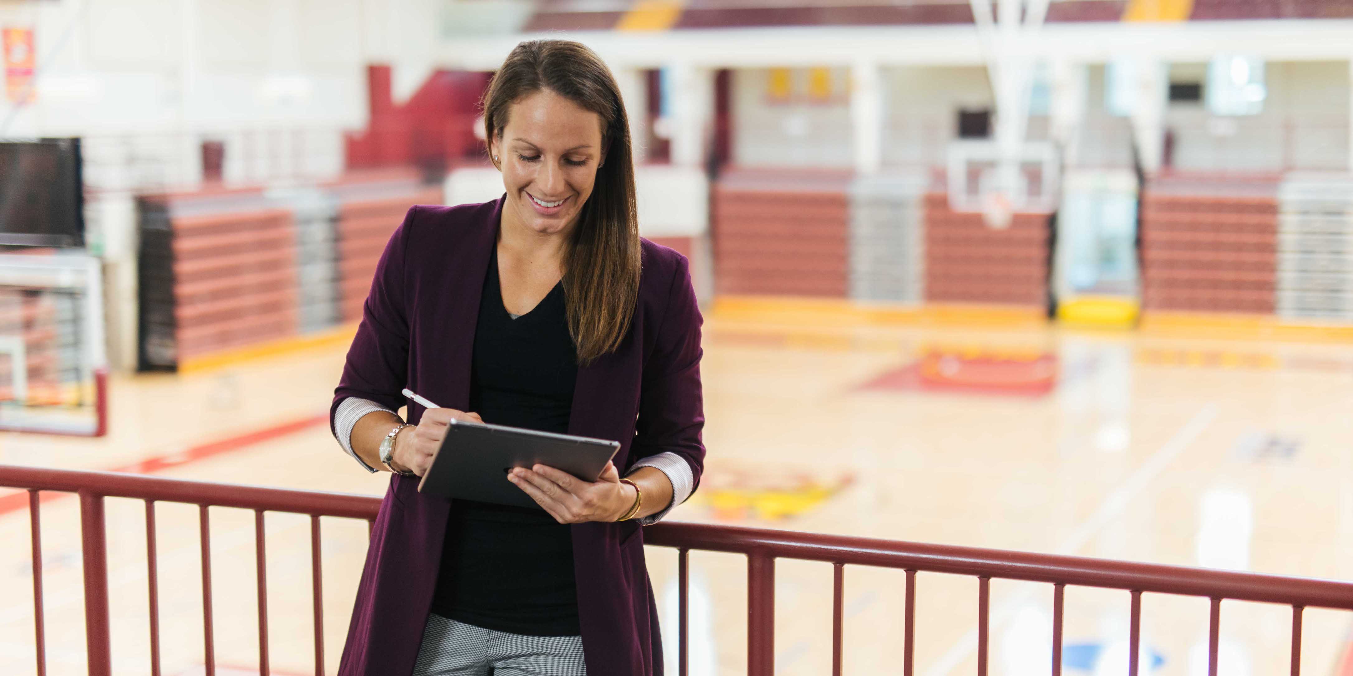 female with tablet in basketball arena