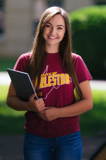college student holding a tablet smiling Charleston